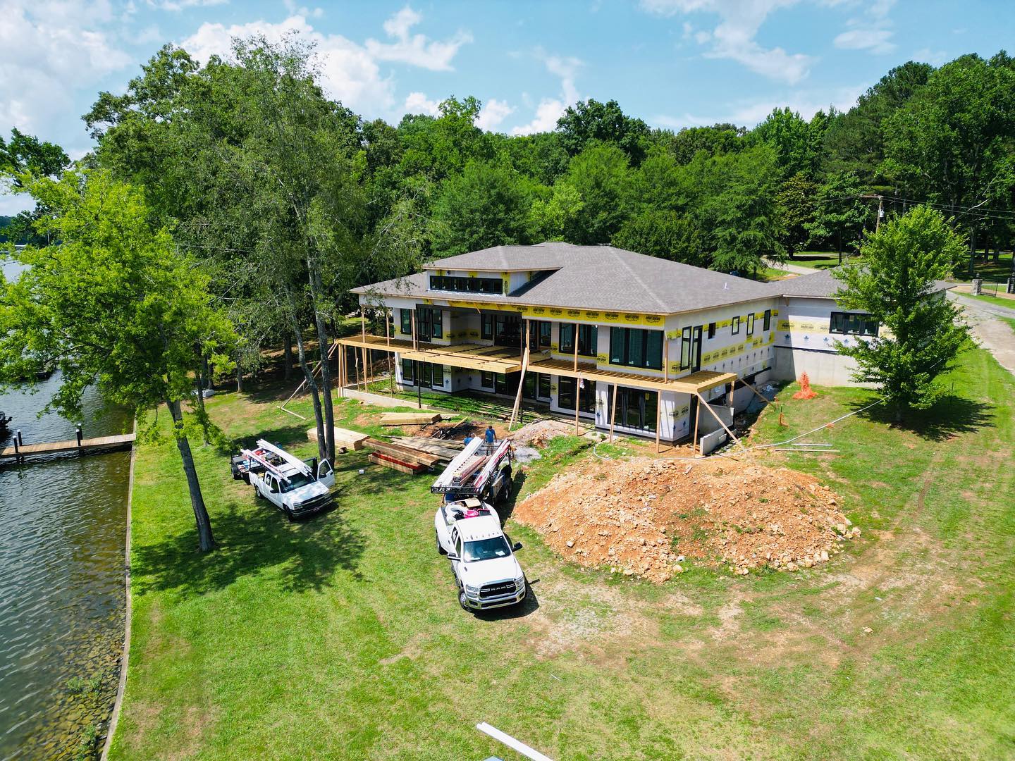 A Baker Company home under construction on the water, crew trucks out front
