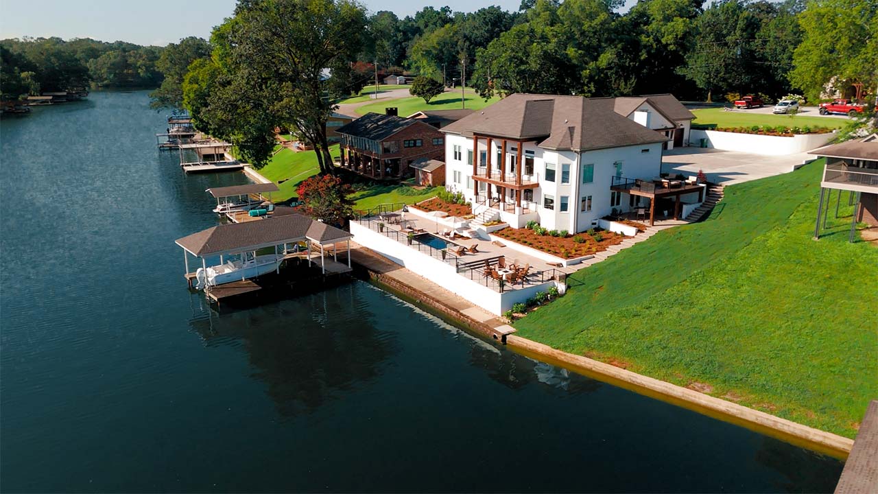 Lakeside estate from the air with terraced patios and a covered boat dock